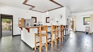 A modern kitchen with a central island, bar stools, and pendant lighting. - Villa Kromboon with a private pool, spectacular views and jacuzzi (Kralendijk)