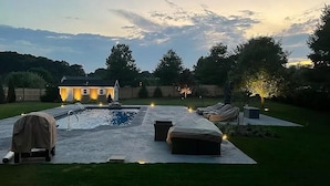 A backyard with a swimming pool, lounge chairs, and a covered grill area. - Beach house, inground pool, hot tub, Large backyard,1.5 Miles from Misquamicut (Westerly)