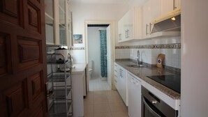 A kitchen with white cabinets, a stainless steel sink, and a built-in oven. - Spacious Apartment with Large Terrace and Garage in Fané de Baix, 50m from Llançà Bypass (Llançà)