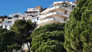 A coastal residential area with multi-story buildings, balconies, and lush greenery.