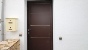 A brown door with a number 5 sign above it, a mailbox, and a stone ledge. - 2-BR Apartment with Terrace, Sea View & Parking - Sleeps 6 (Llançà)