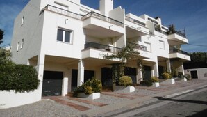 A modern multi-story residential building with balconies, a driveway, and landscaped areas. - Bright apartment with pool and terrace, near the beach (Llançà)