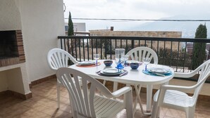 A round table with white chairs on a balcony with a view of a mountain. - Bright apartment with pool and terrace, near the beach (Llançà)