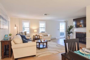 A living room with a fireplace, two sofas, a coffee table, and a television.