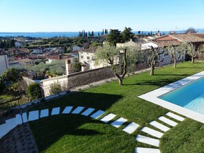 Enjoy a serene retreat with a lawn, swimming pool, and breathtaking views of the surrounding hills and water.