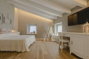 Cozy retreat with a large bed, desk, and TV, set amidst a peaceful atmosphere.
