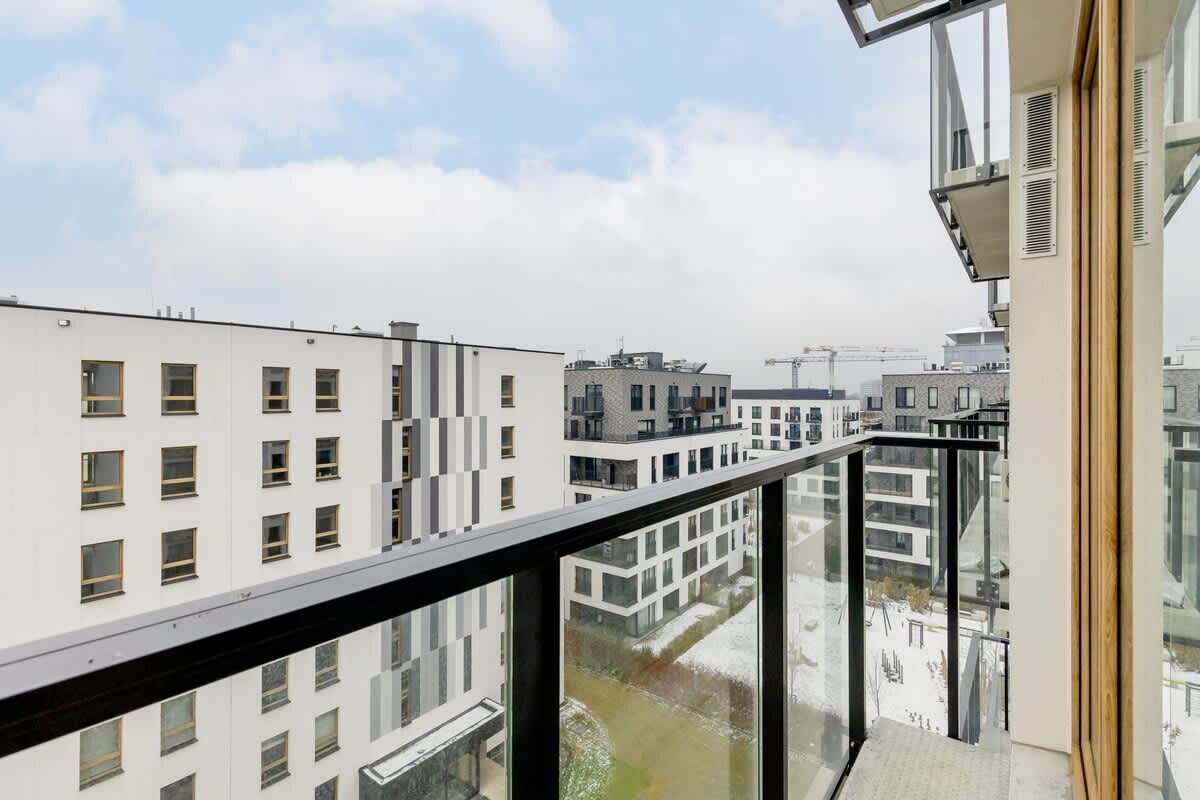 Ein modernes Gebäude mit einem Glasbalkon und Blick auf die Skyline.