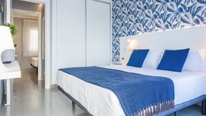 Una habitación de hotel moderna con cama, escritorio y zona de ducha.