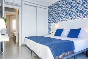 A modern hotel room with a bed, a desk, and a shower area.
