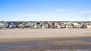 Un quartier résidentiel situé en bord de mer, avec des maisons et une plage de sable.