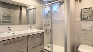 A modern bathroom with a glass-enclosed shower, a double sink vanity, and a toilet. - Berlioz Garden - Jardin,Free Parking,AC,Wifi (Antibes)
