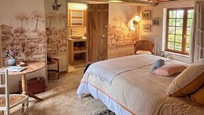A cozy bedroom with a bed, a chair, a small table, and a wardrobe. - Domaine de Blanvatel (Saint-Pierre-en-Auge)