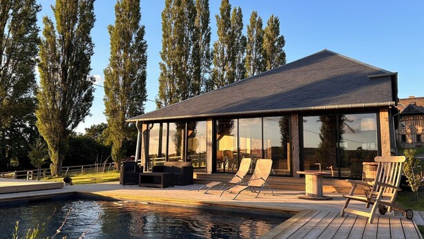 A modern house with a large glass conservatory, a swimming pool, and outdoor seating. - Domaine de Blanvatel (Saint-Pierre-en-Auge)