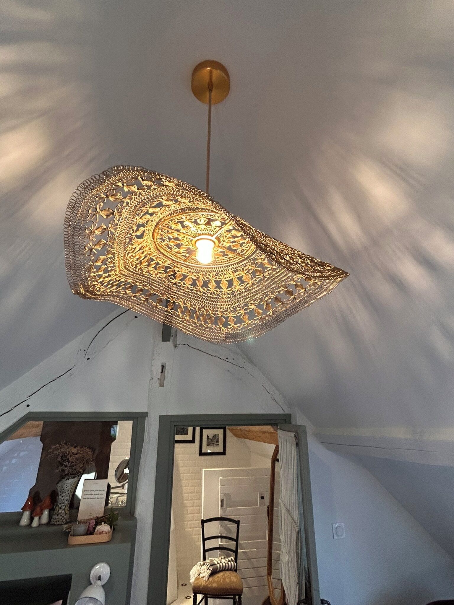 A tent with a hanging light fixture and a chair inside.
