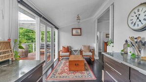 Ein modernes Wohnzimmer mit großem Fenster, einem Holztisch und einem Teppich.
