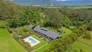 An aerial view of a property with a large house, a swimming pool, and surrounding lush greenery. - Kookaburra Hill, Kangaroo Valley (Kangaroo Valley)