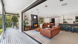 Un salon moderne avec une cheminée, un canapé et un coin bar.