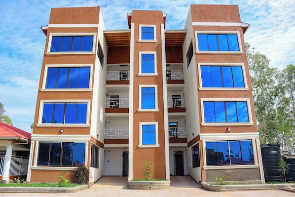 A multi-story residential building with balconies and large windows.