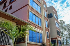 A multi-story building with large windows and a red and beige facade.