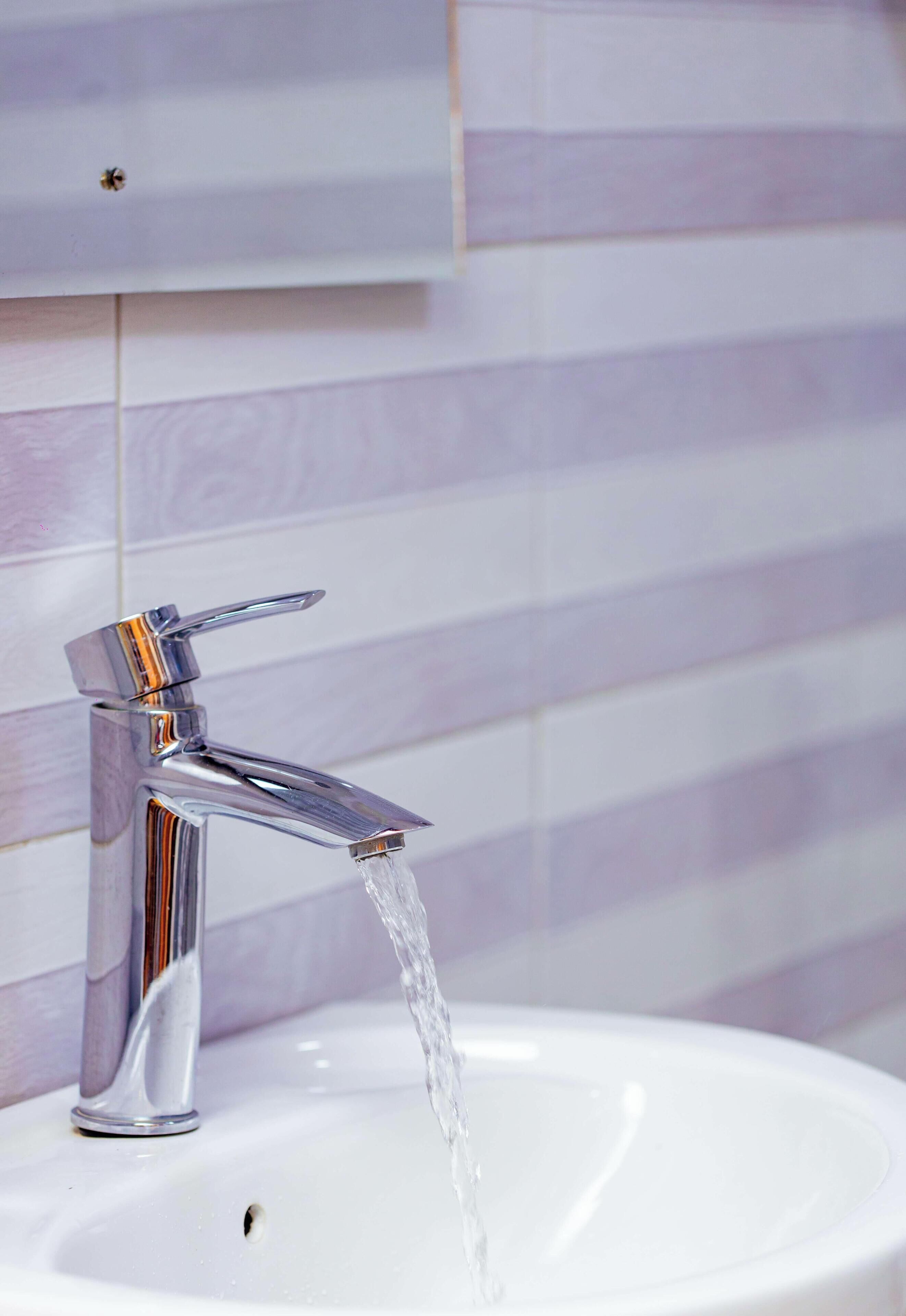 Un baño moderno con grifo cromado y lavamanos blanco.