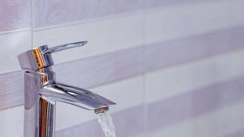 Un baño moderno con grifo cromado y lavamanos blanco.
