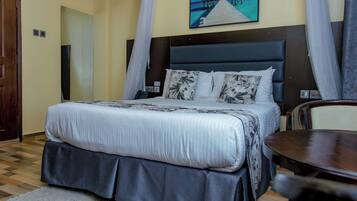 Habitació d'hotel amb un llit, una escriptori i un quadre d'una platja.