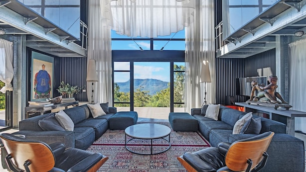A modern living room with a large sectional sofa, a round coffee table, and a view of a mountain. - Sky Ridge, Kangaroo Valley (Kangaroo Valley)
