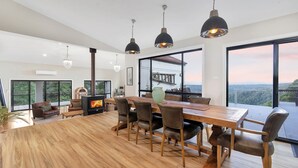 A spacious living room with a large wooden table, leather chairs, and a fireplace. - Valley View Estate, Kangaroo Valley (Beaumont, Kangaroo Valley)