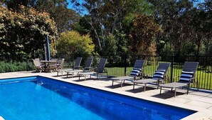 A pool with lounge chairs and a table, surrounded by trees and a fence. - Westbrook, Kangaroo Valley (Kangaroo Valley)