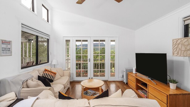 A modern living room with a sofa, a coffee table, a TV, and a fireplace. - Wild Rose Cottage Kiaroo Estate (Barrengarry, Kangaroo Valley)