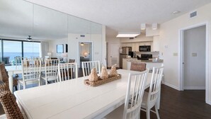 A modern kitchen with white cabinets, a black microwave, and a stainless steel refrigerator. - Windward Pointe 1006- Corner unit, Incredible views (Orange Beach)