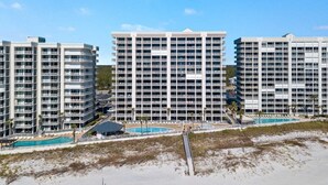 A high-rise hotel with multiple balconies, a swimming pool, and a beach area. - Windward Pointe 1006- Corner unit, Incredible views (Orange Beach)