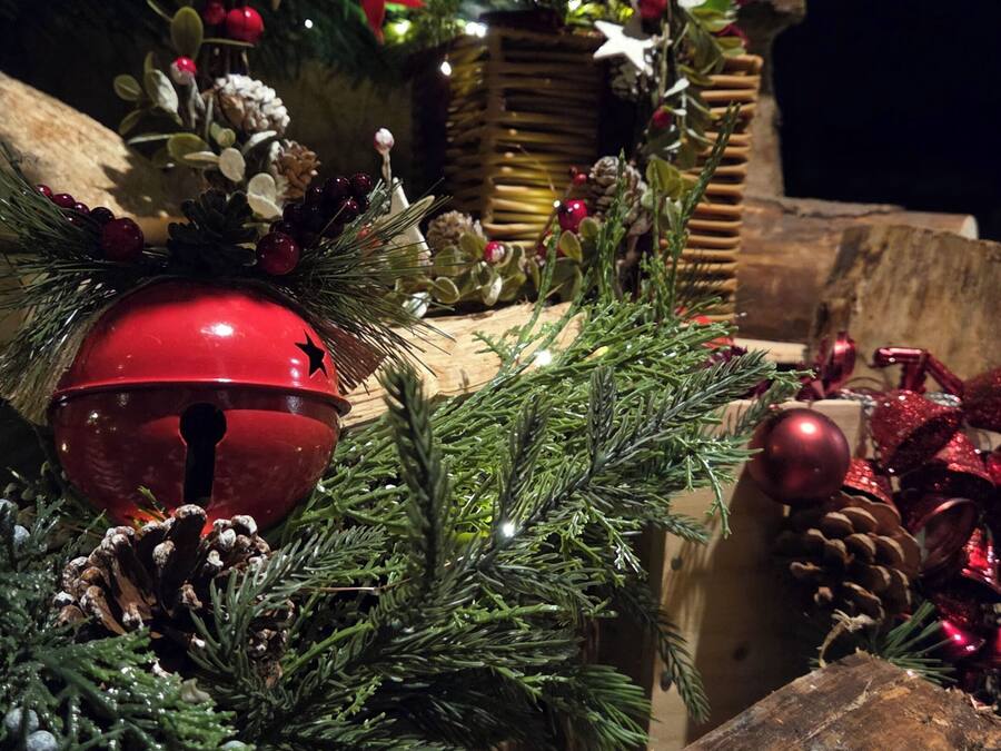 A Christmas tree with ornaments, pine cones, and a star on a wooden surface.