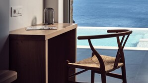 Une pièce avec un bureau en bois, une chaise, un grand miroir et une vue sur l’océan.
