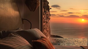 Une chambre avec vue sur l’océan au coucher du soleil.
