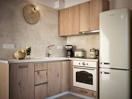 Una cocina moderna con armarios de madera, horno empotrado, refrigerador y cafetera.