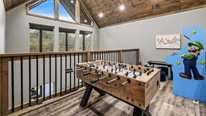 Ein Tischkicker in einem Raum mit Holzboden und schrägverlaufender Decke.