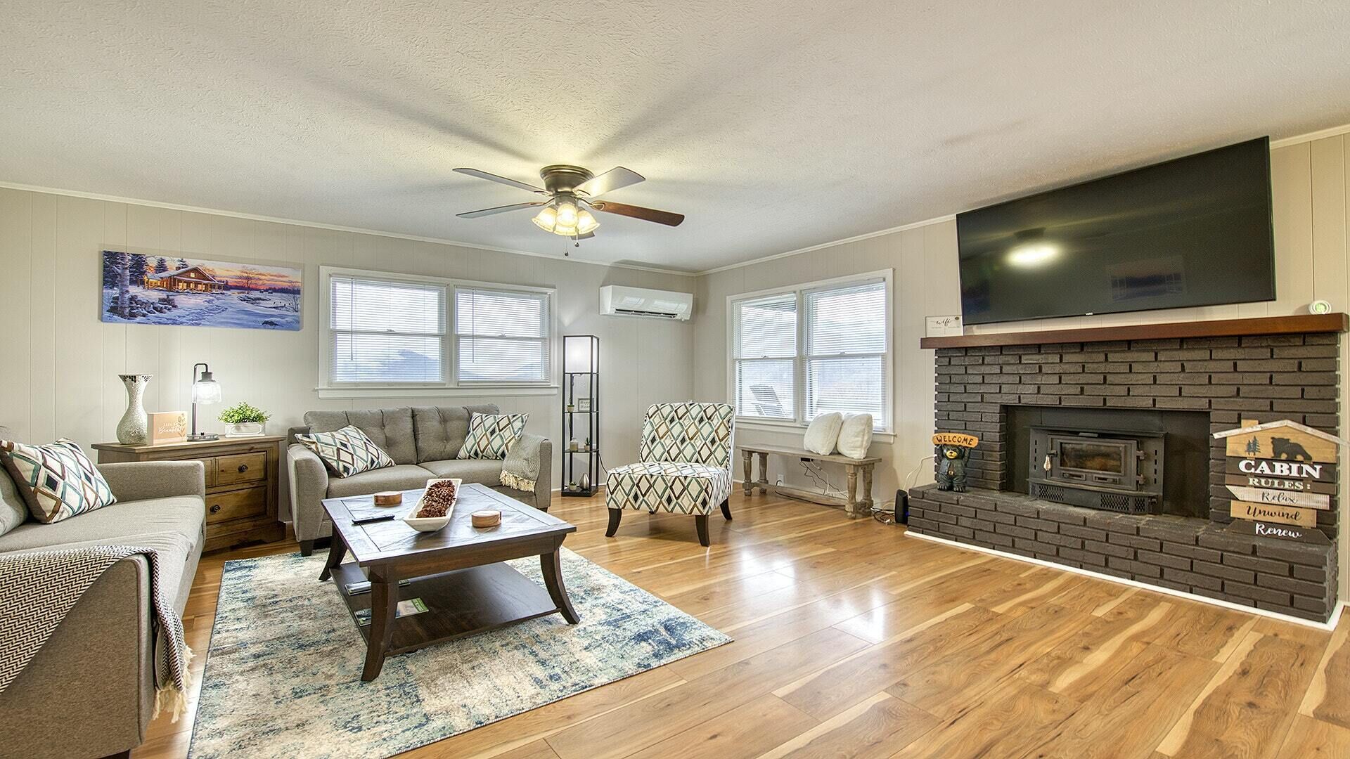 A cozy living room with a fireplace, a sofa, a coffee table, and a patterned armchair.