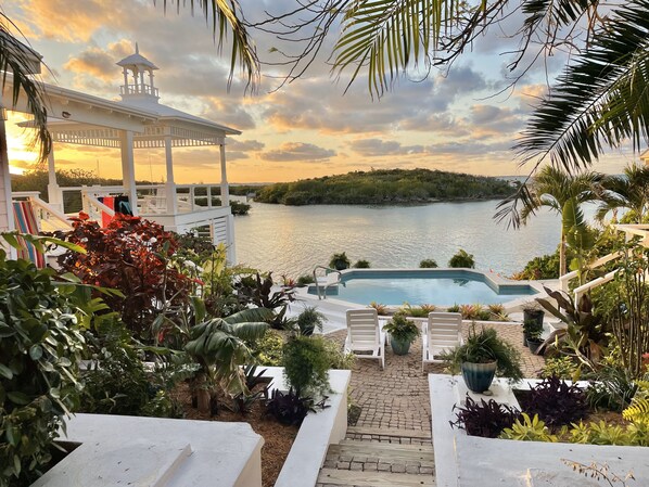 A pool area with a view of a lake and a gazebo.