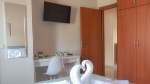 Une chambre d’hôtel équipée d’un lit, d’un bureau, d’une chaise, d’une télévision et d’une armoire.