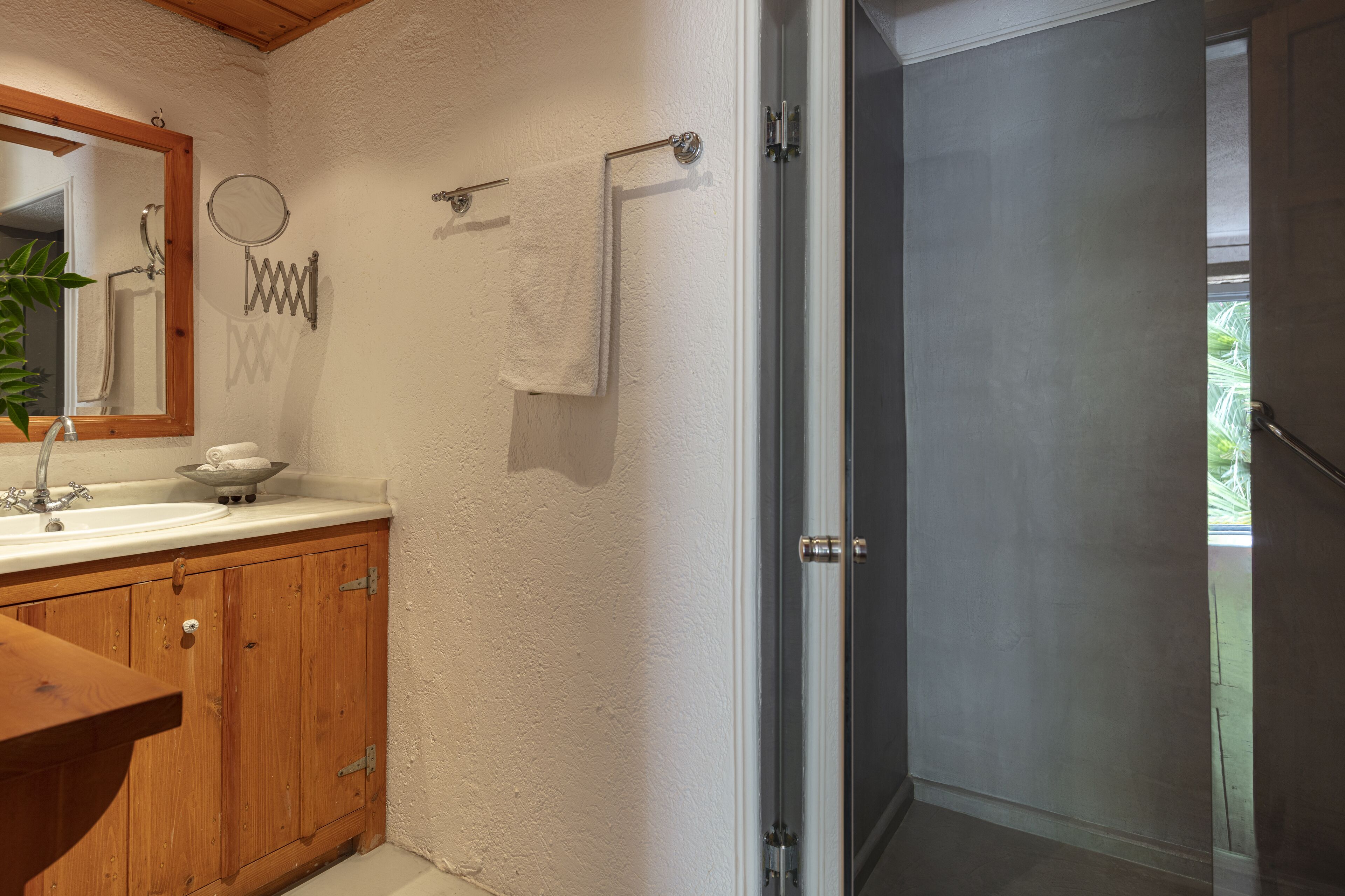 A bathroom with wooden cabinets, a sink, a mirror, and a towel rack.
