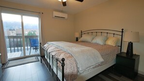 A bedroom with a bed, bedside lamps, a window with curtains, and an air conditioning unit. - 2 King Bedrooms close to pool/hot tub (Eden)