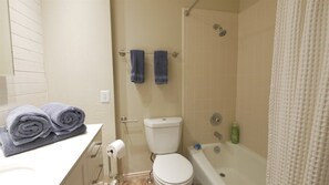 A bathroom with a toilet, bathtub, and two towels on a rack. - 2 King Bedrooms close to pool/hot tub (Eden)