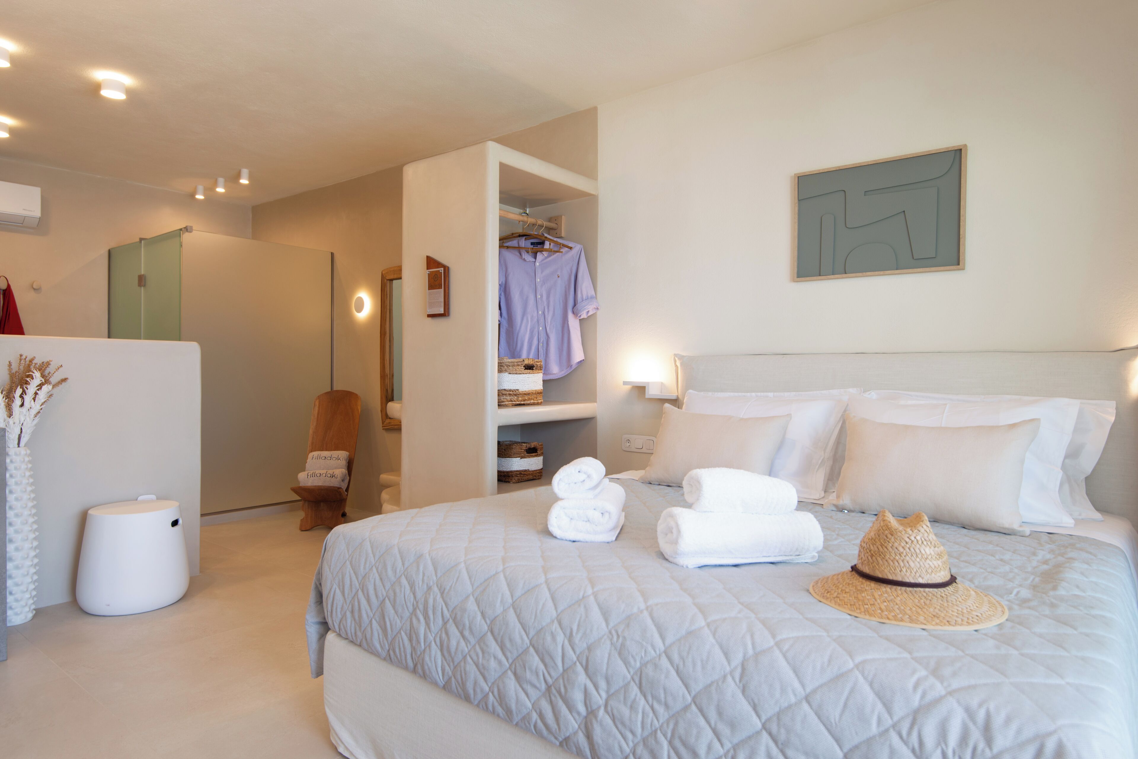 Ein Hotelzimmer mit einem Bett, einem Kleiderschrank, einem Sessel und einem Wandbild.