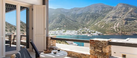 A balcony with a view of a mountainous landscape and a coastal town.