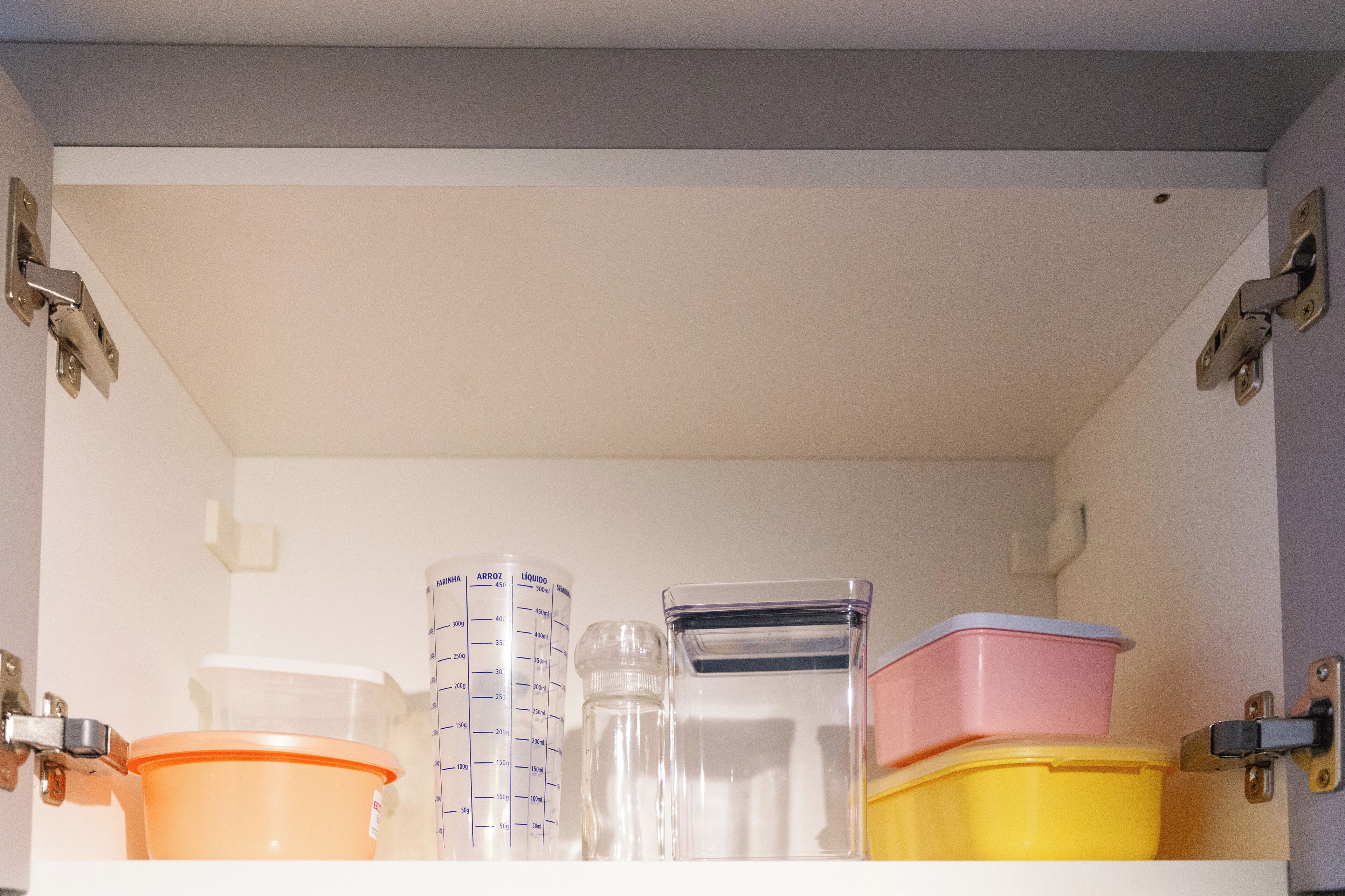A storage cabinet with multiple containers and measuring cups.