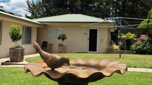 A birdbath in a backyard with a house in the background. - Studio at Beechworth next to the forest. Pet friendly but please let us know. 
. (Beechworth)