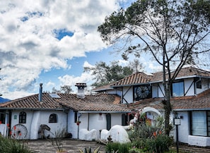 A traditional building with a tiled roof, white walls, and a large wheel structure.