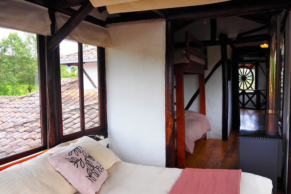 Ein Schlafzimmer mit Bett, Fenster und Blick auf das Dach.