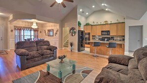 A spacious living room with a brown sofa, a glass coffee table, and a ceiling fan. - Screened Patio: Rincon Home, 18 Mi to Savannah! (Rincon)